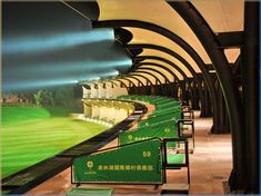 a row of green chairs sitting next to each other in front of a large screen