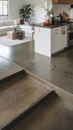 an open kitchen and living room with stairs leading up to it