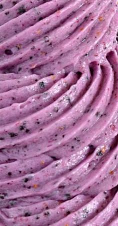 a close up view of a purple cake with sprinkles on the top