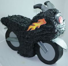 a toy motorcycle made out of black yarn with flames on the front wheel and tires