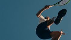 a man jumping in the air with a tennis racquet on his back legs