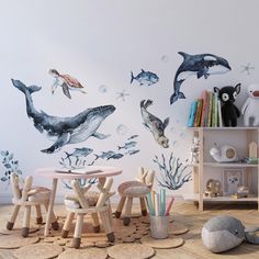 an ocean themed children's room with dolphins and other marine creatures painted on the wall