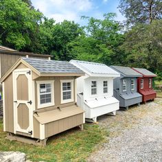 a row of small houses sitting next to each other on top of a grass covered field