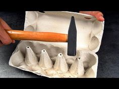 an egg carton with six eggs in it and a large knife sticking out of the top