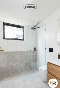 a bathroom with white tile and wood cabinets