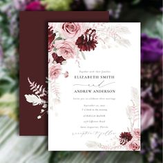 the burgundy and white floral wedding card is displayed on a table with flowers in the background