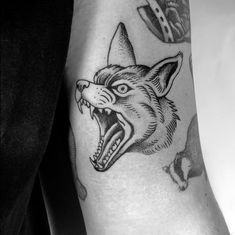 a man's arm with an angry wolf tattoo on it