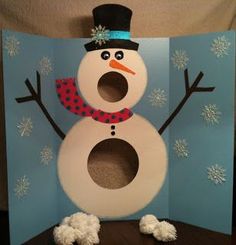 a snowman made out of toilet paper on top of a wooden table in front of a blue wall