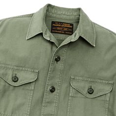 This versatile overshirt provides an added layer of protection on cool days in the field. Patterned after our original iconic Jac-Shirt that’s been a favorite since the 1970s, its versatility makes a sure go-to favorite. The strong midweight fabric is a reverse-sateen weave, smooth on the inside for easy layering. Sturdy buttons secure the front, chest-pocket flaps, and adjustable cuffs. Straight hem for untucked wear. Spread collar. | Filson Field Jac-shirt - WshdFtgGrn Size Large Cotton Military Tops For Outdoor Activities, Collared Green Shirt For Outdoor, Green Outdoor Shirt With Pockets, Green Shirt With Pockets For Outdoor Activities, Green Shirt For Fall Outdoor Activities, Green Shirt For Outdoor Fall Activities, Green Shirt For Fall Outdoor Events, Green Fall Outdoor Shirt, Green Top With Pockets For Outdoor Use