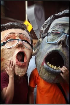 two people with masks on their faces and one has his mouth open to the camera