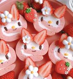 hello kitty cupcakes are decorated with strawberries and flowers on a pink plate