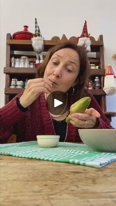 a woman eating food from a bowl on top of a wooden table