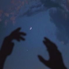 two hands reaching for the moon in the sky