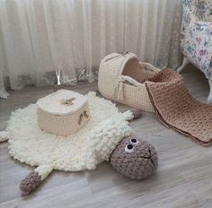 two crocheted shoes and a sheep rug on the floor