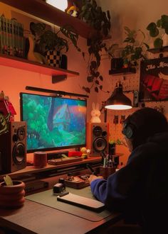 a person sitting at a desk in front of a tv with a fish on it