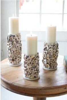 four candles sitting on top of a wooden table