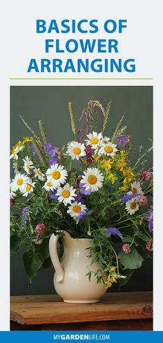 a white vase filled with flowers on top of a wooden table