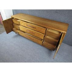 a wooden dresser sitting on top of a carpeted floor