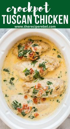 a white bowl filled with chicken, spinach and cheese soup on top of a marble counter