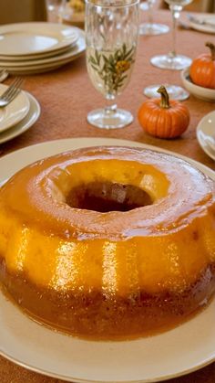 a bundt cake sitting on top of a white plate next to plates and glasses