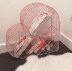 a magazine rack with magazines on it in a corner next to a white cow skin rug