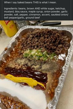 a hot dog covered in lots of toppings on top of tin foil next to other food items