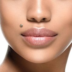 a woman's face is shown with a pearl drop on her lip and nose