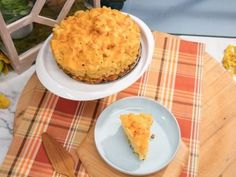 a pie sitting on top of a white plate next to a wooden cutting board and knife