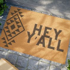 a door mat with the words hey y'all on it next to a potted plant