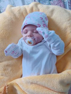 a baby laying on top of a yellow blanket