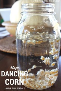 a jar filled with popcorn sitting on top of a wooden table