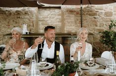 a group of people sitting around a table drinking wine