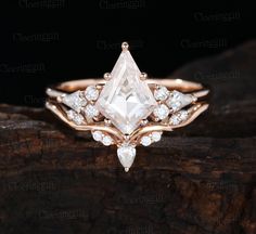 an engagement ring with a pear shaped cut diamond surrounded by small white and clear stones