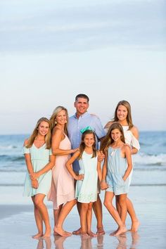 a family posing for a photo on the beach