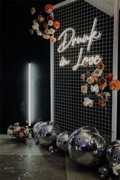 some silver balls and flowers are on the floor next to a sign that says broke in love