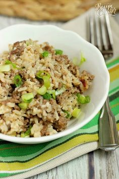 a white bowl filled with rice and meat on top of a green and yellow table cloth