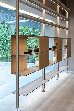 an empty room with shelves and vases on the wall