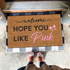 someone standing in front of a welcome mat that says,'welcome hope you like pink '