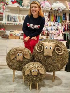 a woman sitting on top of hay covered sheep sculptures