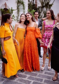 three women in dresses standing next to each other with one woman holding her arm around the other