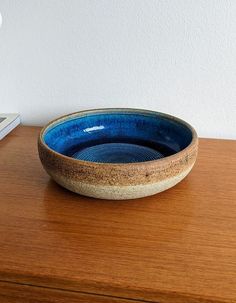 a blue bowl sitting on top of a wooden table