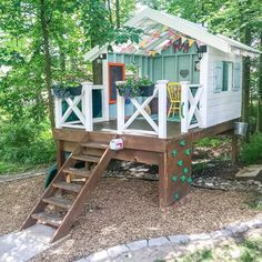 a small wooden house with stairs leading up to it