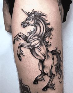 a black and white photo of a unicorn tattoo