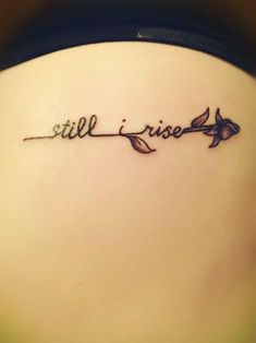 a woman's back with the words still rise written in cursive writing