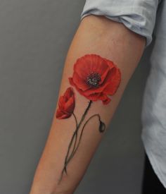 a woman's arm with two red flowers on it