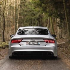 an audi car is parked on the side of the road in front of some trees