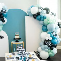 a table topped with balloons and cake next to a wall