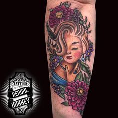 a woman's face with flowers and leaves on her leg, next to a tattoo