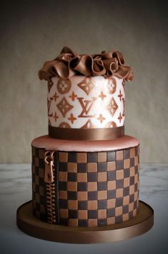 a three tiered cake decorated with brown and white designs