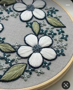 an embroidery project with white and green flowers